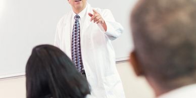 Doctor giving a lecture to attentive students in a classroom.