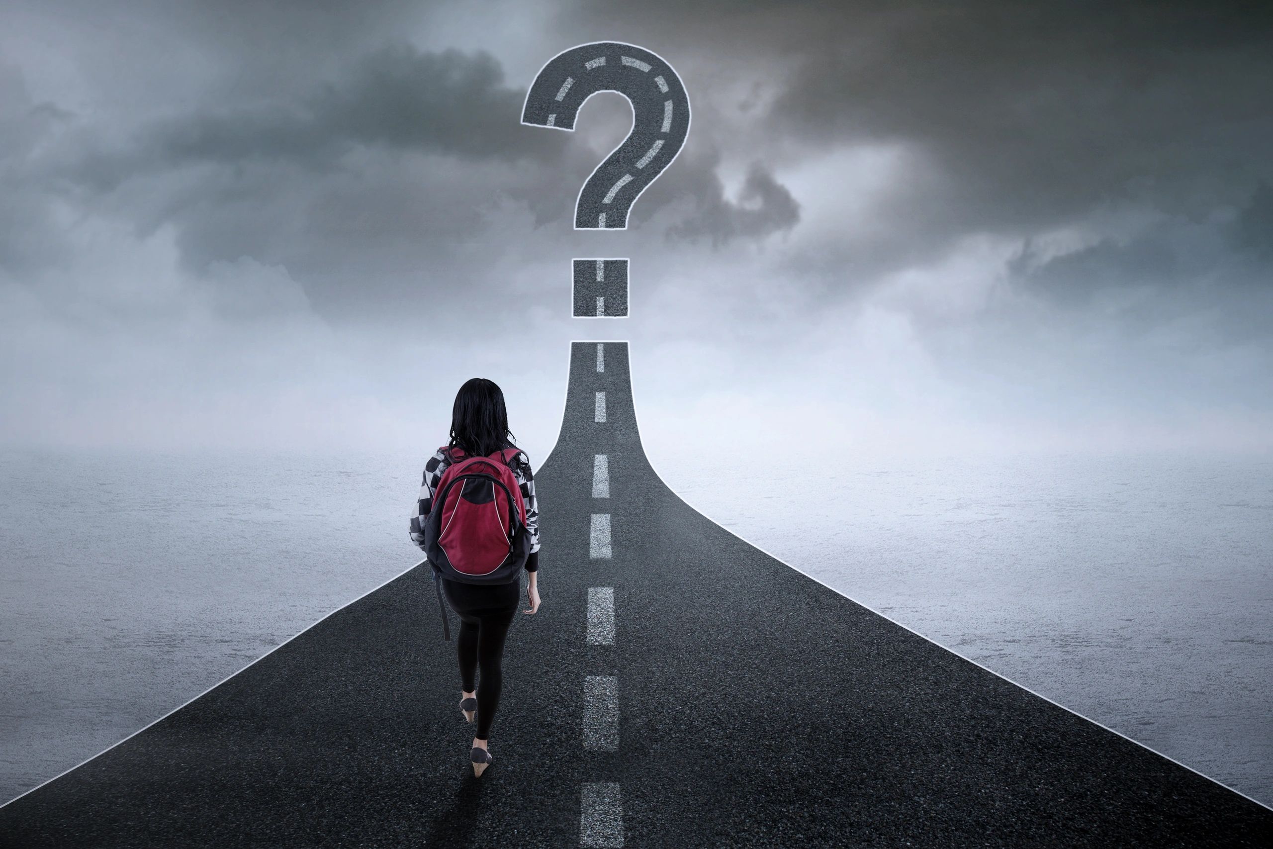 Person facing a road shaped like a question mark.