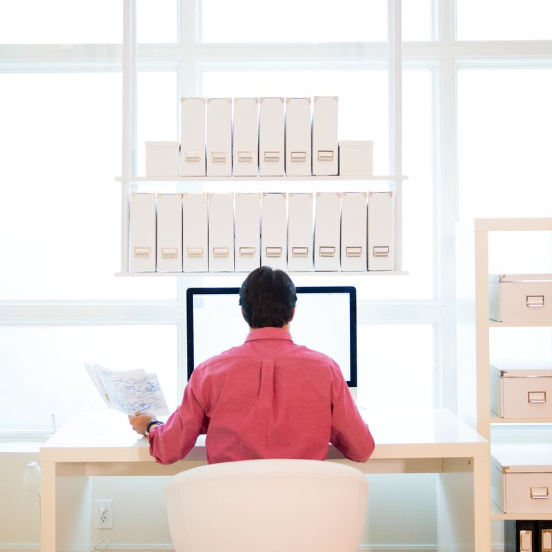 Businessman looking at large computer monitor in modern design office.