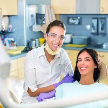Dentist and patient smiling in a dental clinic.