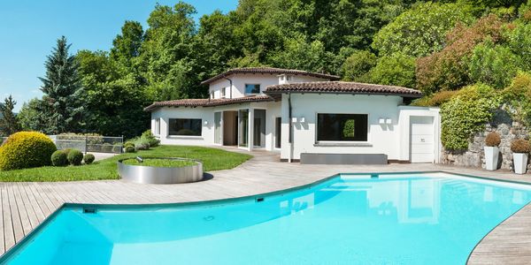 Modern house with a large pool and lush greenery.