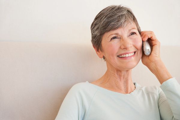 A happy woman with short gray hair talking on the phone
