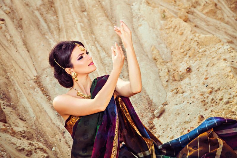 Young woman in traditional indian dress against the sand background