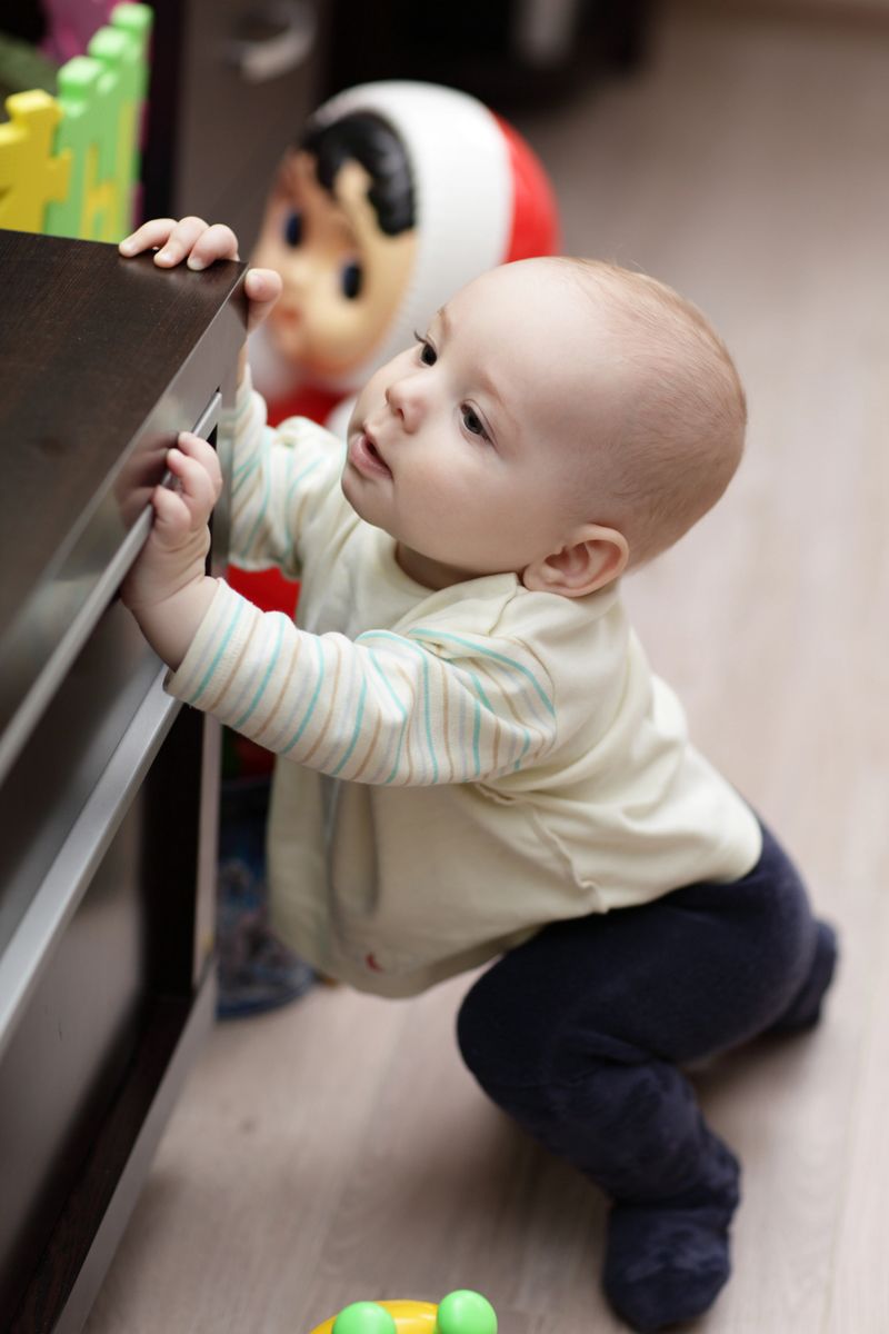 The curious kid mounting on a cupboard at home