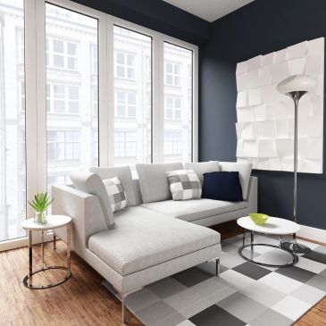 Bright living room with gray sectional sofa and large windows.