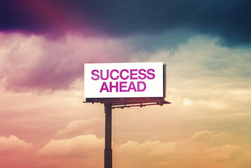 Success Ahead Motivational Message on Outdoor Advertising Billboard Hoarding Against Cloudy Sky