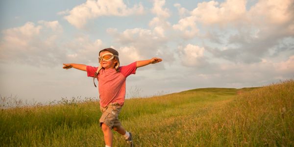 Boy running through a grassy field

