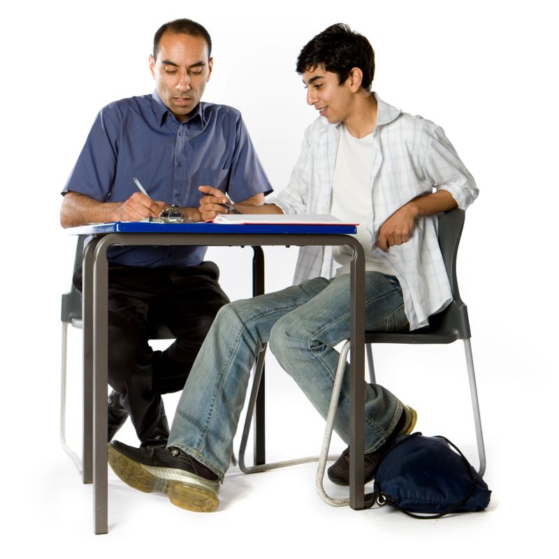 A teenage student receives some individual tuition from his teacher.