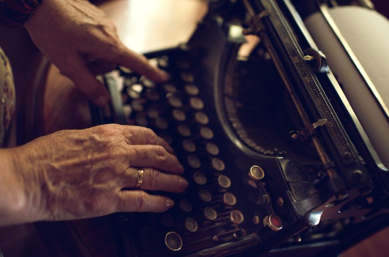 Close up of unrecognizable senior woman using typewriter.