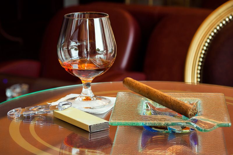 Cognac and cuban cigar on glass table