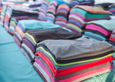 Stacks of colorful folded clothes arranged neatly on a table.