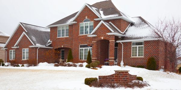 Large brick house with snow-covered yard.