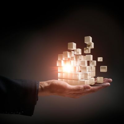 Hand holding floating glowing cubes forming a 3D structure.
