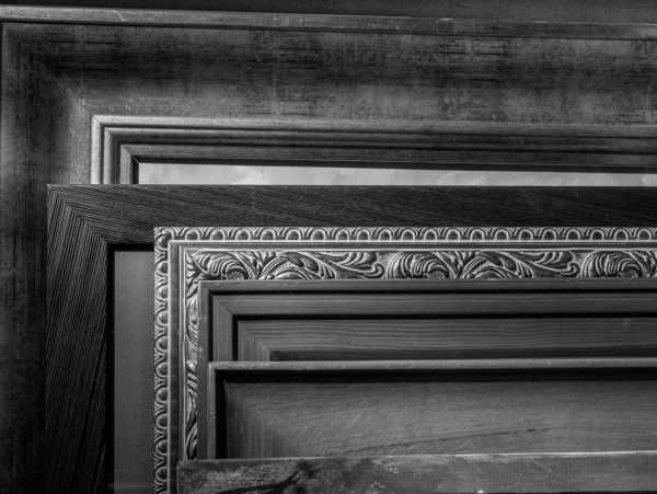 Stacked ornate and simple wooden frames.
