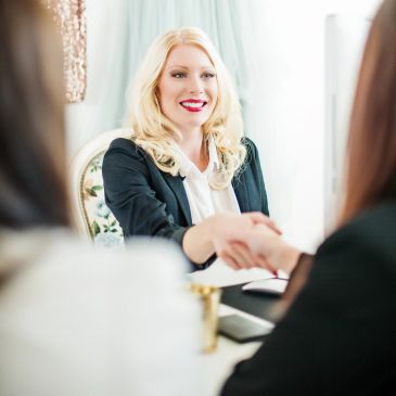 Smiling woman shaking hands during a business meeting.