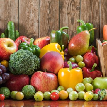 A colorful assortment of fresh fruits and vegetables arranged on a wooden surface.