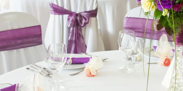 Elegant table setup with purple decorations and glassware.
