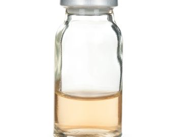 A small glass vial with a light brown liquid inside.