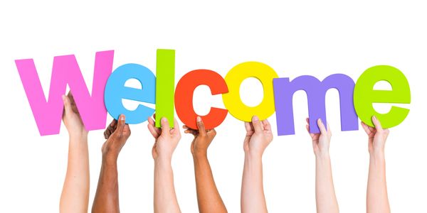 Colorful Welcome blocked letters with diverse hands holding the letters up.