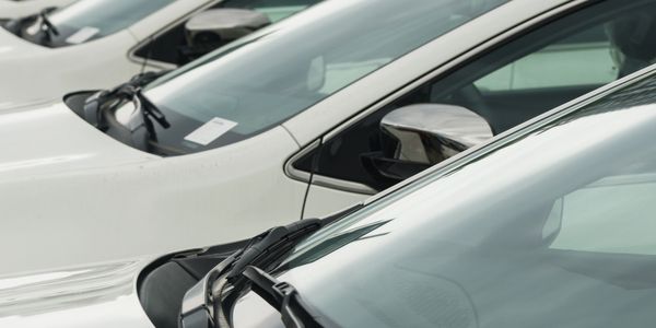 Row of white cars parked closely together.