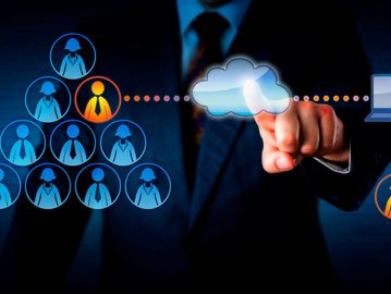 Businessman interacting with a digital cloud network connecting people and technology.