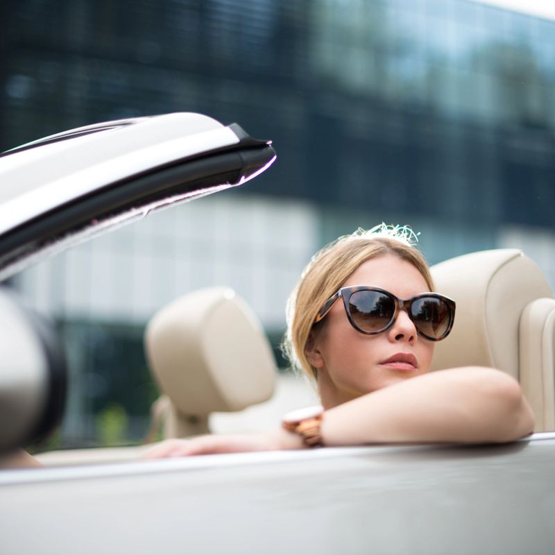 Fashionable woman driving the convertible car.