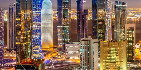 Night view of a modern city skyline with illuminated skyscrapers.