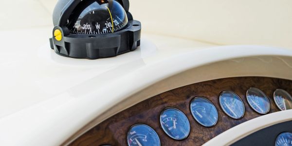 Boat dashboard with a compass and gauges.