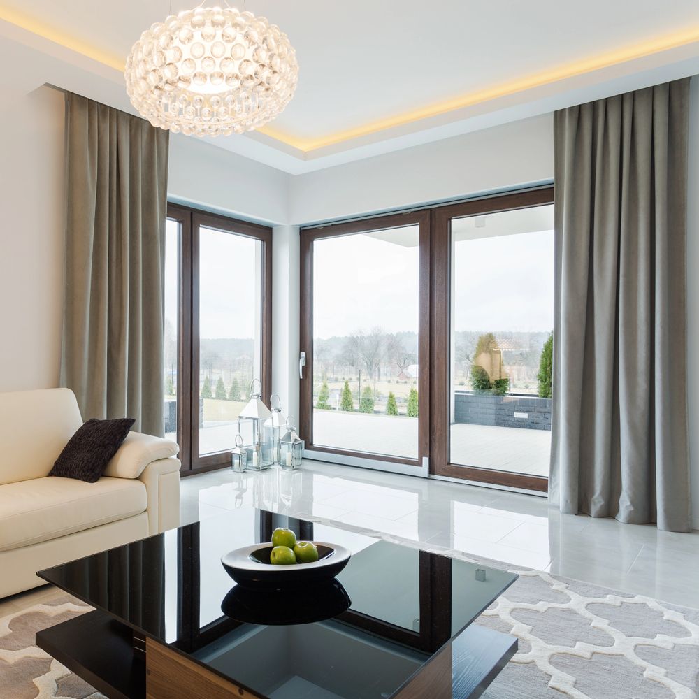 Modern living room with large windows, neutral tones, and contemporary decor.