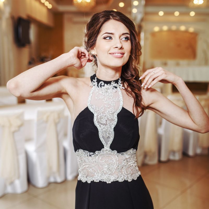 Teenage girl wearing fancy prom dress, posing on  school-leaving party.