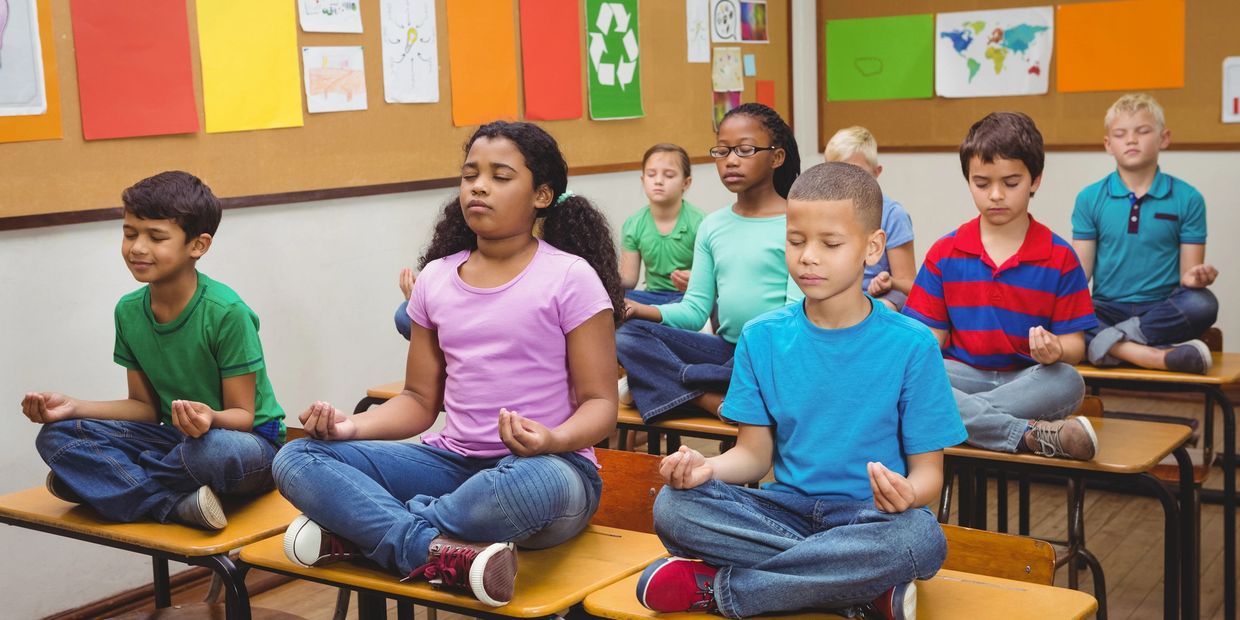 Students practicing mindfulness together in a classroom setting
