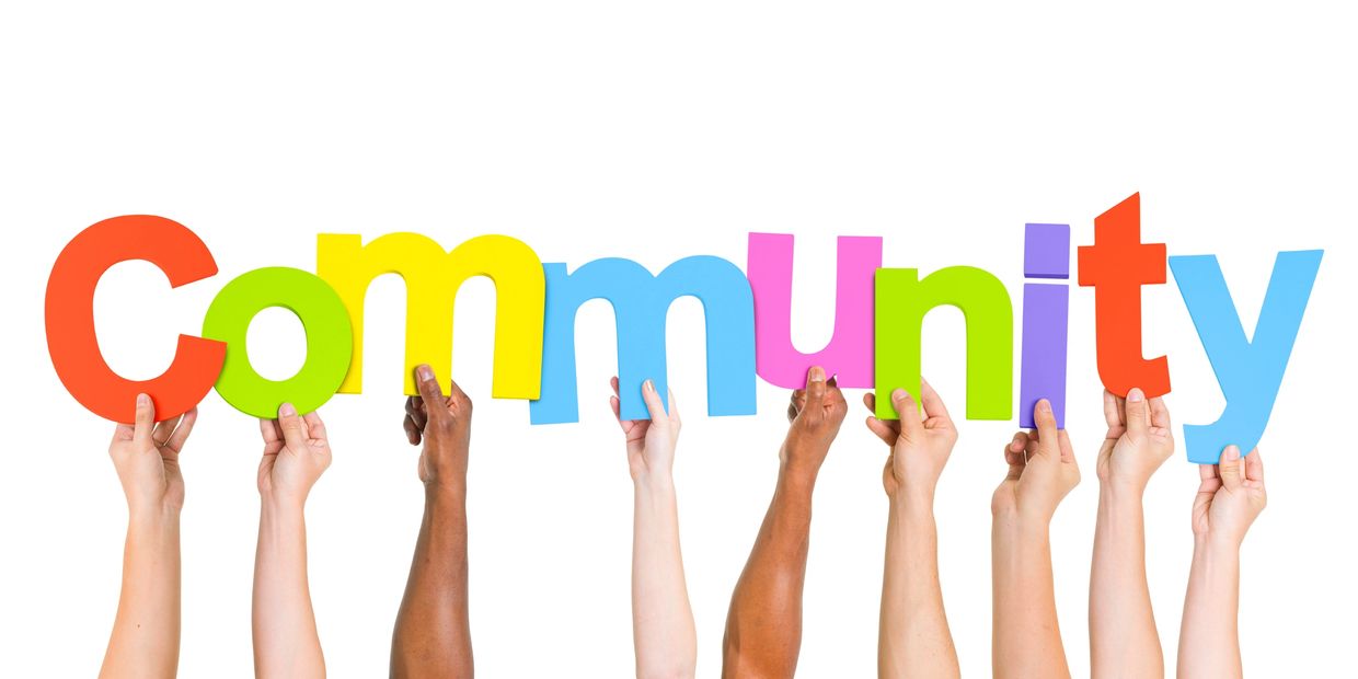 Diverse hands holding colorful letters spelling 'Community'.