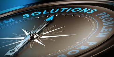 Compass needle pointing to the word 'SOLUTIONS' among problem-related terms.