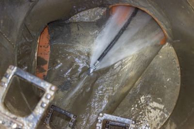 Water spraying inside a large pipe or tank.