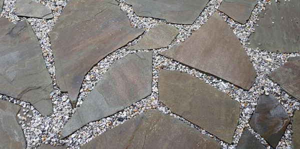 Irregular stone tiles set in gravel forming a decorative pathway.