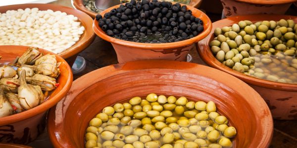 Various bowls with different types of olives and beans.