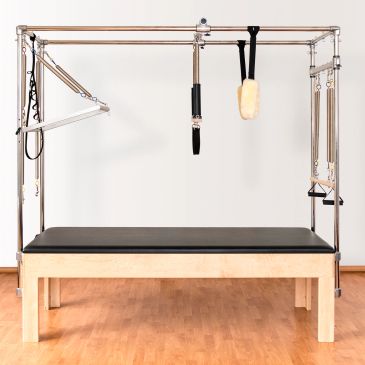 Pilates reformer machine with wooden base and metal frame.