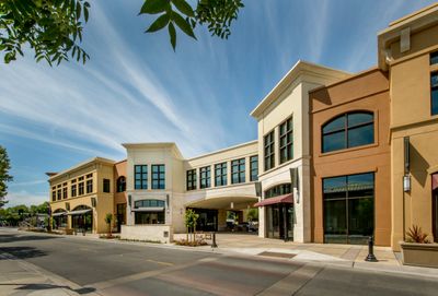 Modern commercial buildings under a clear blue sky.