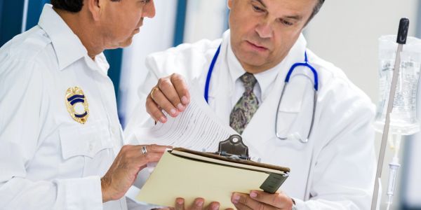 Doctor and security officer reviewing medical documents together.