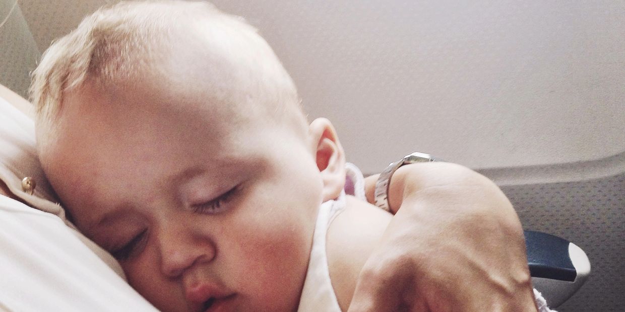 A baby peacefully sleeping on a person's chest, embraced gently.