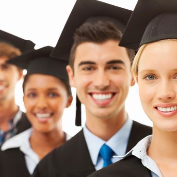 Four diverse graduates smiling in caps and gowns.