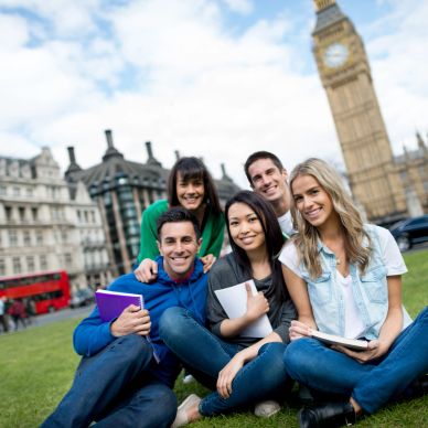 Cinco jóvenes sonrientes estudiando en el parque cerca del Big Ben.