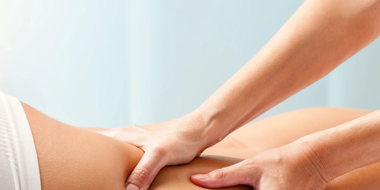 Hands giving a thigh massage to a person lying down at lymphoCare, Nurturing Lymphatic wellness