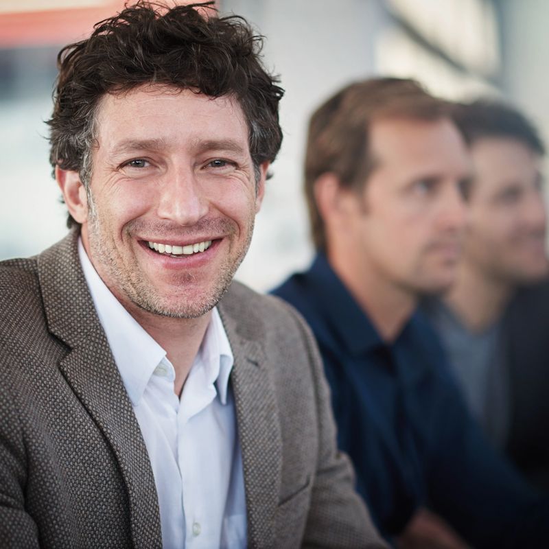 Portrait of a smiling office worker sitting with colleagueshttp://195.154.178.81/DATA/i_collage/pi/shoots/784650.jpg