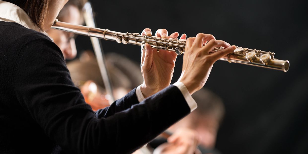 Close-up of person playing flute.