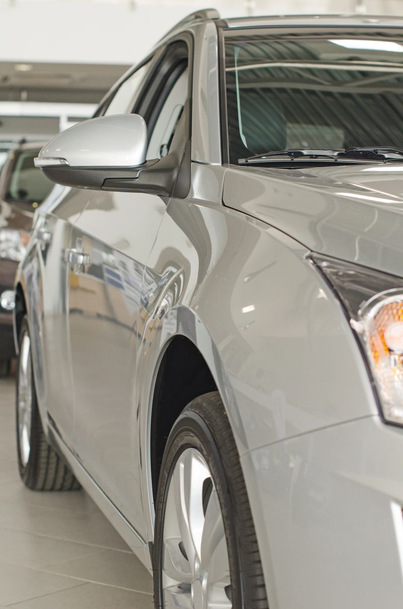 Part of grey car at dealership salon.