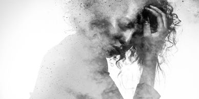 Black and white artistic portrait of a woman dissolving into smoke.