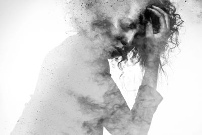Artistic black and white image of a person dissolving into smoke.
