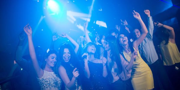 Personas disfrutando en una fiesta con luces azules.