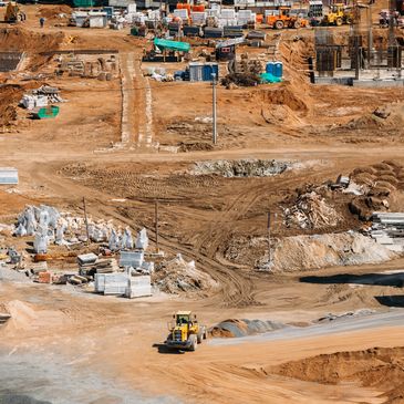 Busy construction site with machinery and building materials scattered around.